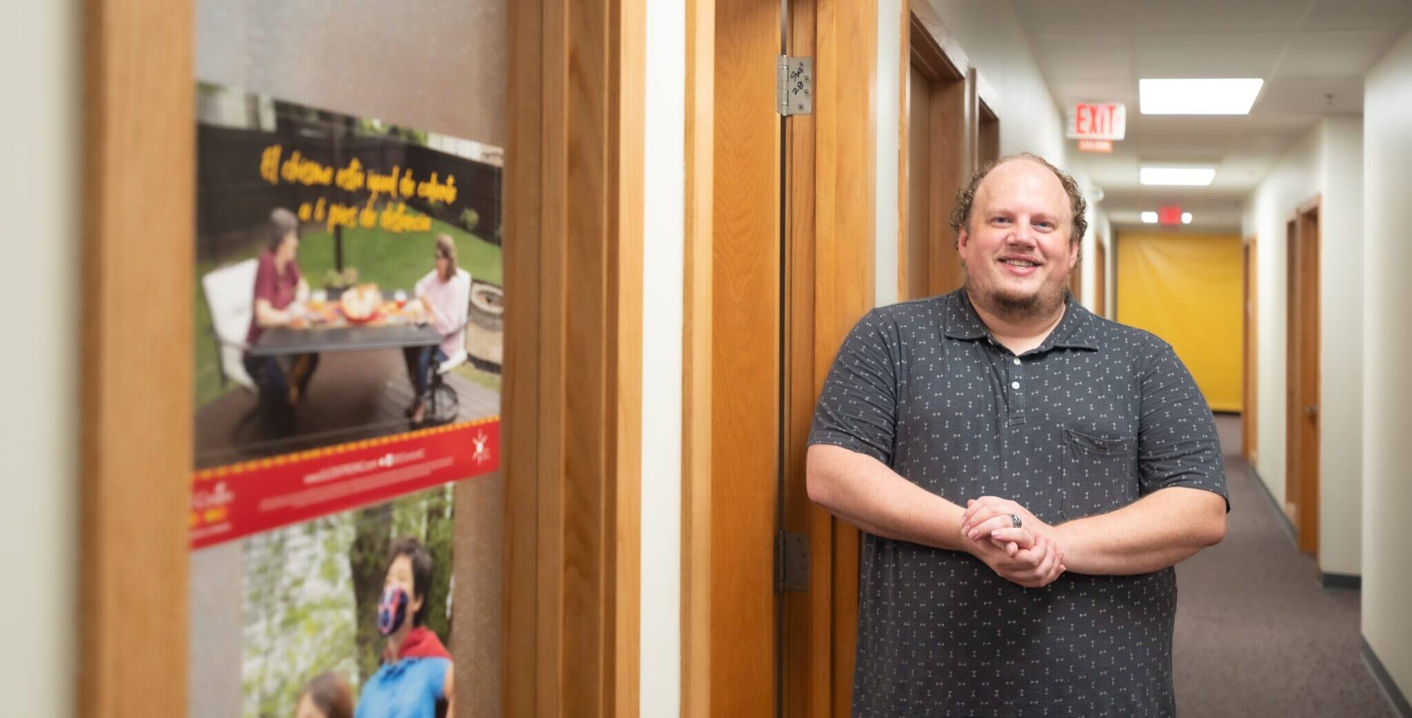 man standing near doorframe in a hallway